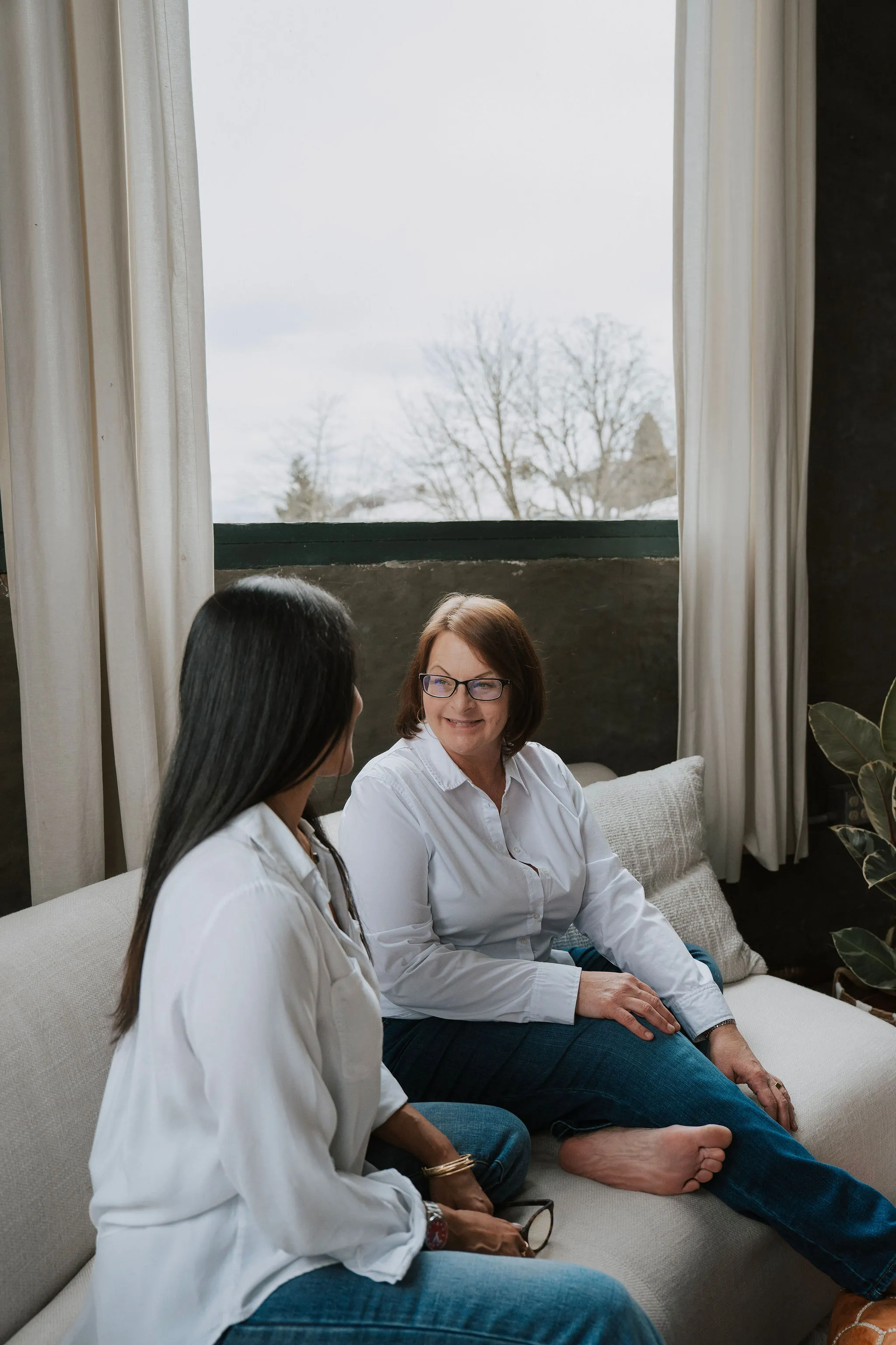 Two women in conversation on a sofa.